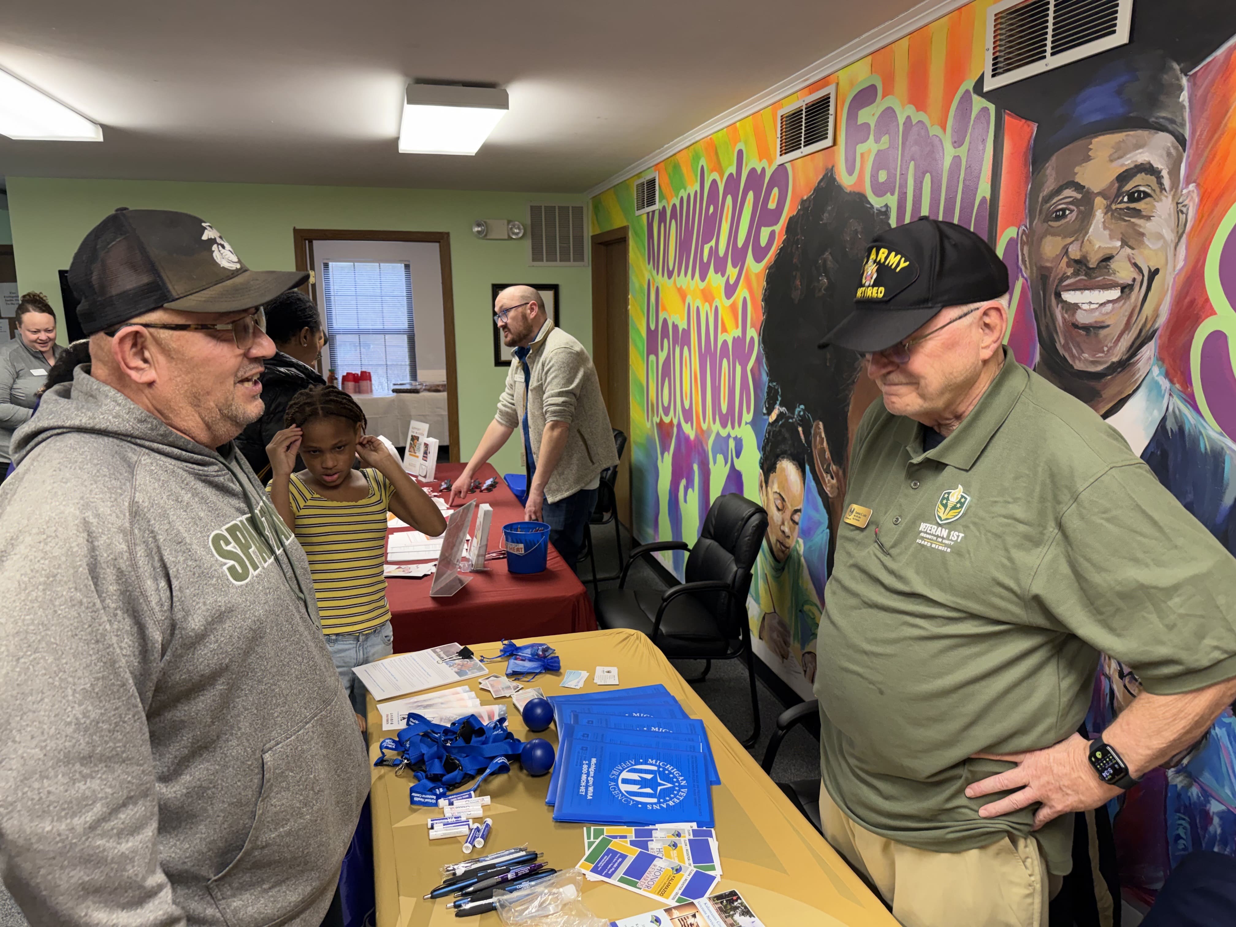 Veterans chatting by mural
